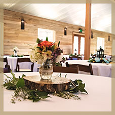 Image of tables with center pieces in a wedding reception - Whispering Oaks Wedding Venue